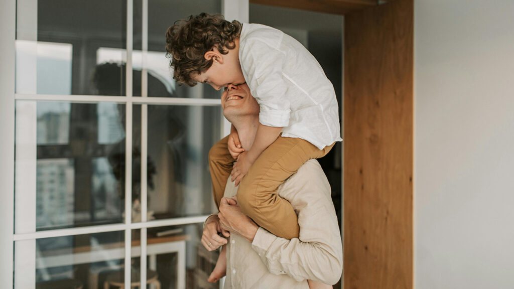 Father with son on shoulders, reaping the benefits of mindful parenting