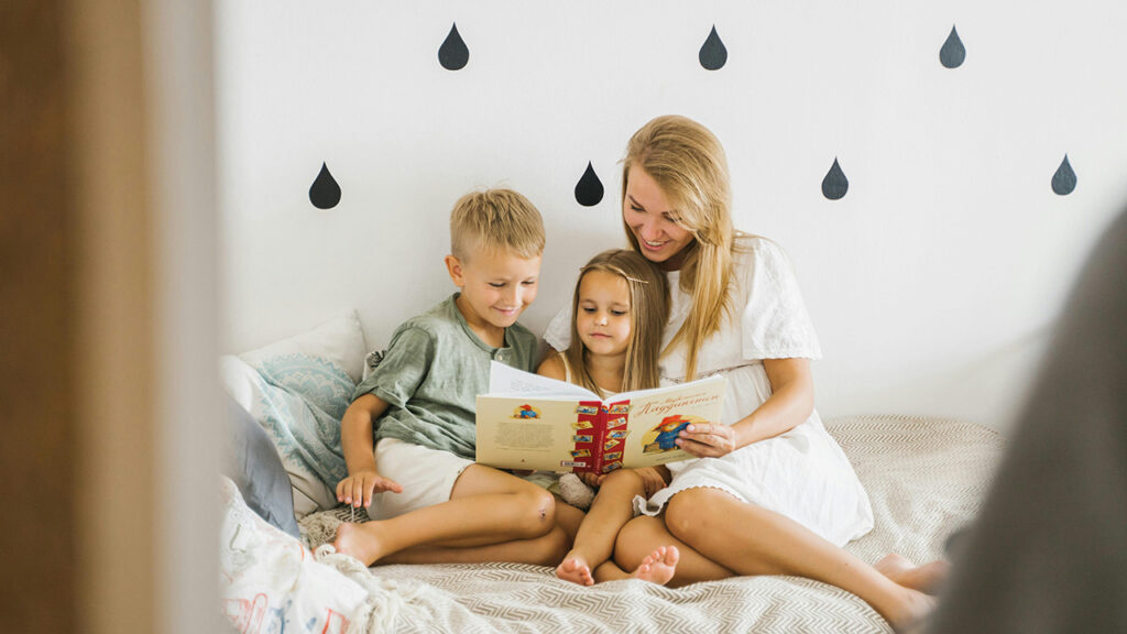 Mother reading to her son and daughter, practicing mindful parenting